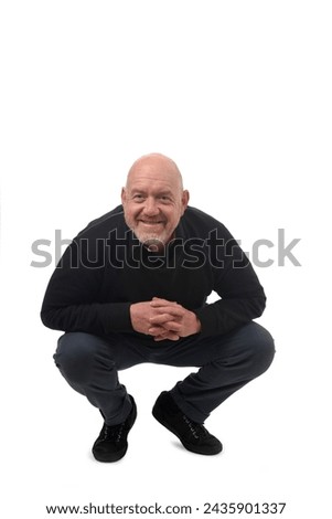 crouching man looking at camera on white background