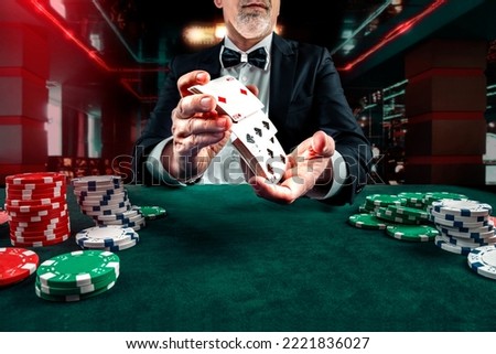 Croupier or casino dealer at gambling club or casino. Close up of male hand. Gambling concept.