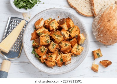 Croutons with herbs, garlic and cheese from white bread or baguette. Served for salad or soup. Selective focus, top view