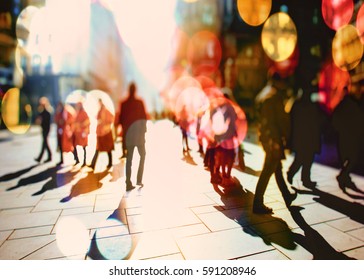 Crowd of anonymous people walking on sunny streets in the city 