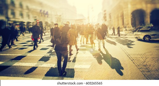 Crowd Of Anonymous People Walking On Sunset In The City Streets