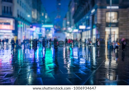 Crowd of anonymous people walking on busy Vienna city night streets