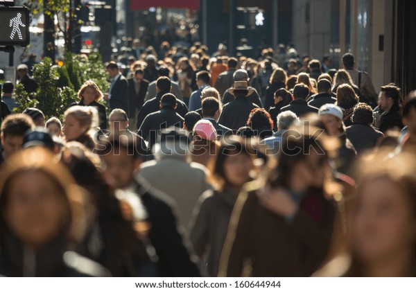 Crowd of anonymous people walking on busy New York\
City street
