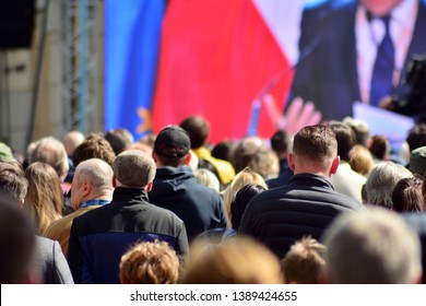 Crowd Attending Political Meeting. Large Group Of   People As Audience To Politician's Speech Outdoors In Big Screen.