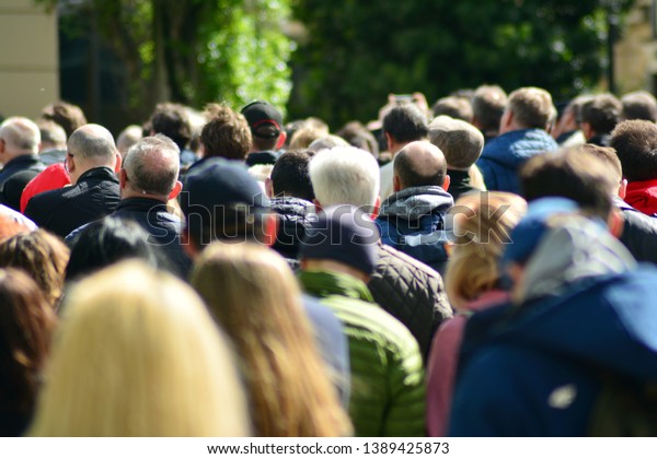 Crowd\
attending political meeting. Large group of   people as audience to\
politician\'s speech outdoors in big\
screen.