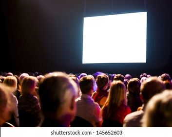 Crowd Audience In Dark Looking At Bright Screen