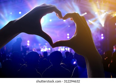 Crowd Of Audience At During A Concert With A Heart Shaped Hands Shadow