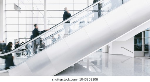 Crowd Of Blurred Business People Rushing On Escalators