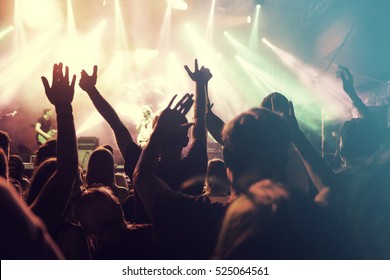 Crowd at concert - Cheering crowd in front of bright colorful stage lights - Shutterstock ID 525064561
