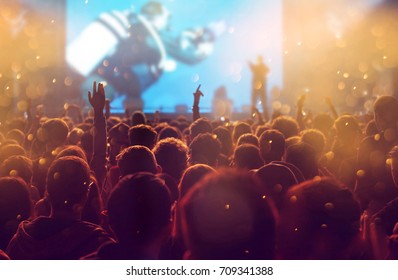 Crowd at concert - Cheering crowd in front of bright colorful stage lights - Shutterstock ID 709341388