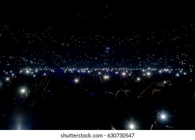 Crowd At Concert With Lights And Camera Flash On