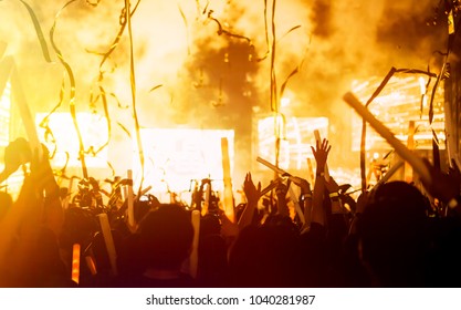 Crowd Of Concert Stage Lights And People Fan Audience Silhouette Raising Hands Or Glow Stick Holding In The Music Festival Rear View With Spotlight Glowing Effect And Smoke