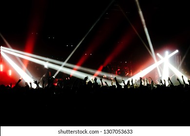 Crowd Is At The Concert. White And Red Spotlights On The Stage. Bright Background