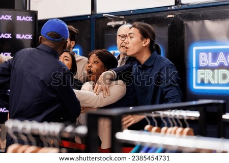 Crowd of diverse people standing at clothing store entrance going crazy during Black Friday. Shoppers arguing fighting with African American man security guard while waiting in line. Bargain hunting