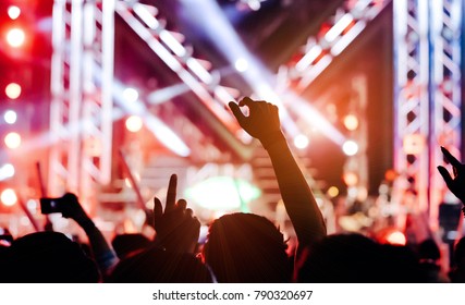 Crowd Of Hands Up Concert Stage Lights And People Fan Audience Silhouette Raising Hands Or Glow Stick Holding In The Music Festival Rear View With Spotlight Glowing Effect