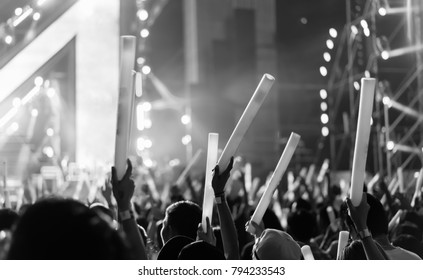 Crowd Of Hands Up Glow Stick Concert Stage Lights And People Fan Audience Silhouette Raising Hands In The Music Festival Rear View With Spotlight Glowing Effect