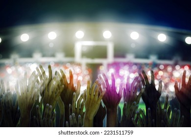 Crowd hands of soccer fans supporting their team on the stadium at nighttime - Powered by Shutterstock