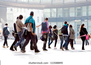 A crowd moving against a background of an urban landscape. Young people.