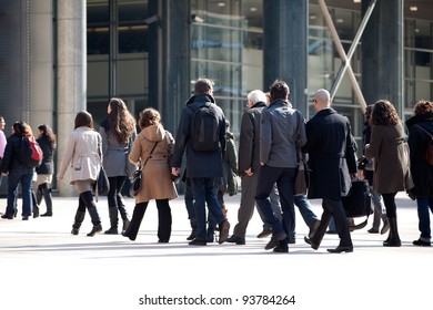 A Crowd Moving Against A Background Of An Urban Landscape.