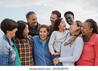 Crowd of multi generational people hugging each other outdoor - Multiracial friends having fun together - Powered by Shutterstock