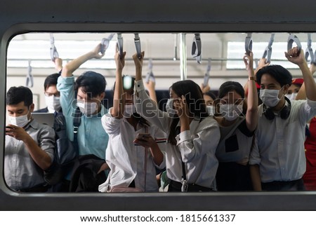 Crowd of passengers on Urban Public Transport Metro. 
Asian people go to work by public transport. Face Mask protection against virus. Covid-19, coronavirus pandemic