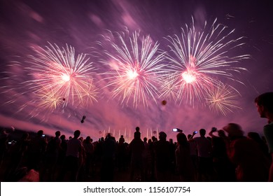 a crowd of people came to the festival, a festival of fireworks, explosions of pyrotechnic charges, volleys of salutes against the backdrop of happy people rejoicing in the beautiful spectacle, multic