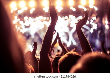 A crowd of people celebrating and partying with their hands in the air to an awesome Dj. High ISO grainy image. - Shutterstock ID 311964026