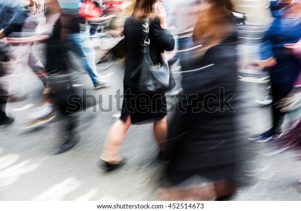 crowd of people crossing a street in the city in\
abstract motion blur