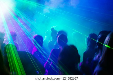 Crowd Of People Dancing Under Disco Laser Light.