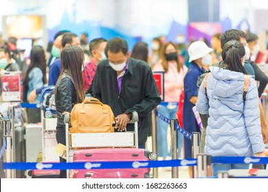 Crowd Of People In Masks With Luggage Waiting In Line In Airport During Coronavirus Quarantine