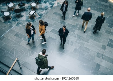 Crowd Of People In Modern Office Building Hallway. Business People Walking Across Office Lobby.