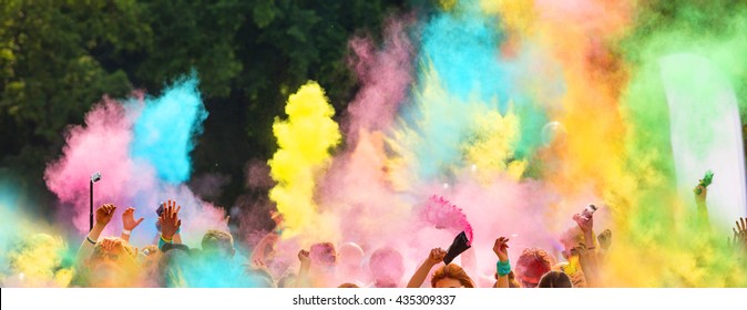 Crowd of people on color run throwing colored powder