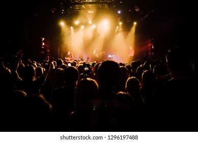 Crowd Of People On A Concert Looking To The Stage With Bright Lights