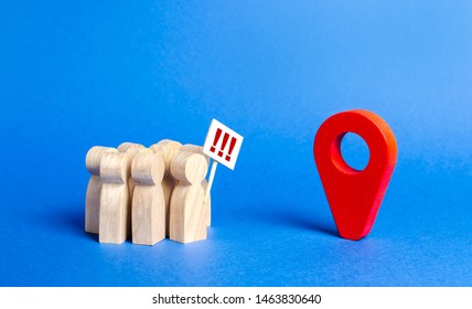 A Crowd Of People With Posters Stands In Front Of A Red Navigation Pointer. Concept Of Fees For A Meeting Or Route Of The March. Coordination Of The Rally With The Government. Coordination Of Protest.