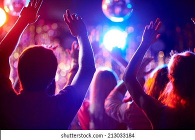 Crowd Of People With Raised Arms Dancing In Night Club