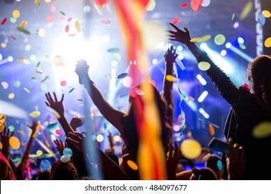 Crowd of people raising their hands in the air on a music festival.