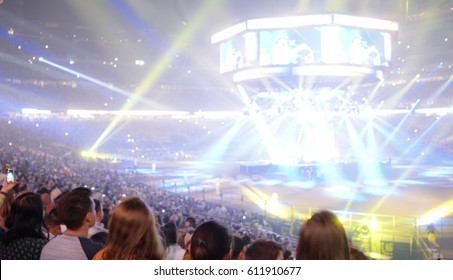 Crowd Of People In A Stadium Watching A Popular Rock Music Concert With Spotlights, Screens And Glowing Lights