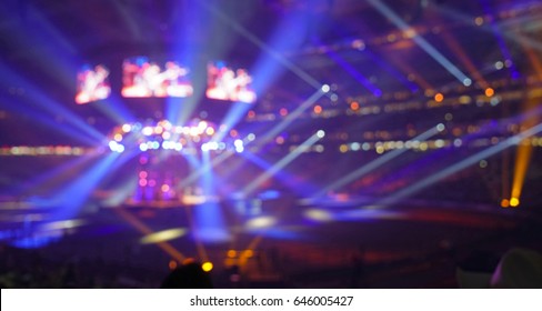 Crowd Of People In A Stadium Watching A Popular Rock Music Concert With Spotlights, Screens And Glowing Lights.