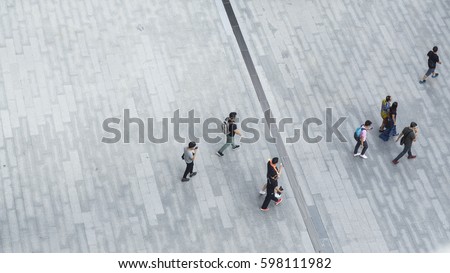 Crowd of people walk on open space concrete pavement from top view ,bird eye view