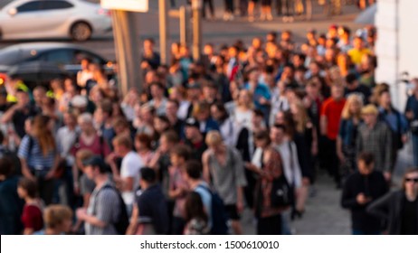 A crowd of people is walking along the road. Blurry people. A group of anonymous people walks through the evening city, by the setting sun. Blurred background for text and copy space. - Shutterstock ID 1500610010