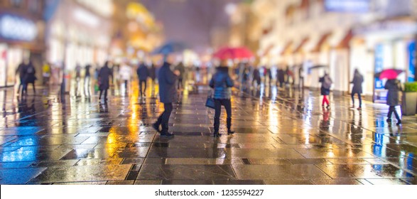 Crowd Of People Walking On The Night And Rainy Streets In The City