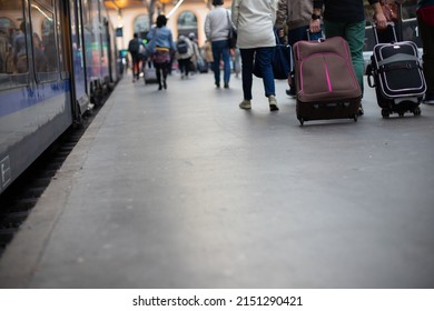 
Crowd Of People Walking In The Same Direction On The Platform Of A Station Next To A Train For A Departure On Vacation Or To Go To Work