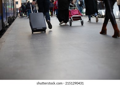 
Crowd Of People Walking In The Same Direction On The Platform Of A Station Next To A Train For A Departure On Vacation Or To Go To Work