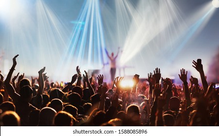 crowd with raised hands at concert festival banner