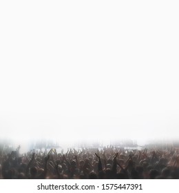 Crowd With Raised Hands At A Music Concert Against A Stage Lit By A Blinding Flash Of White Light. Entertainment Concept Background With Space For Copy And Design, Blurred Filter.