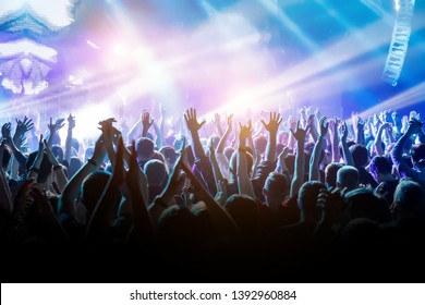 Crowd with raised hands on music concert. - Shutterstock ID 1392960884
