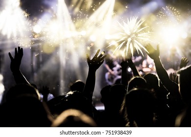 crowd with raised hands watching fireworks - New Year concept - Shutterstock ID 751938439