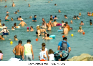 Crowd at sea. Lots of people in the sea water. Blurred image.