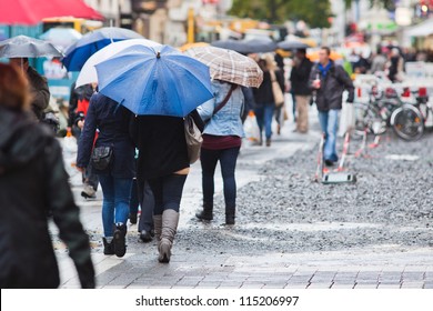 Crowd Of Shopping People With Umbrellas On A Rainy Day In The City