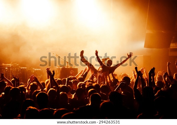 Crowd surfing during\
a musical performance